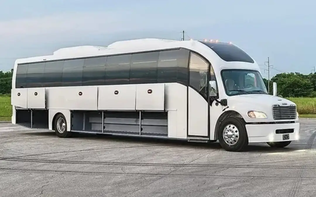 A white coach bus with its luggage bays open, front three-quarter view.