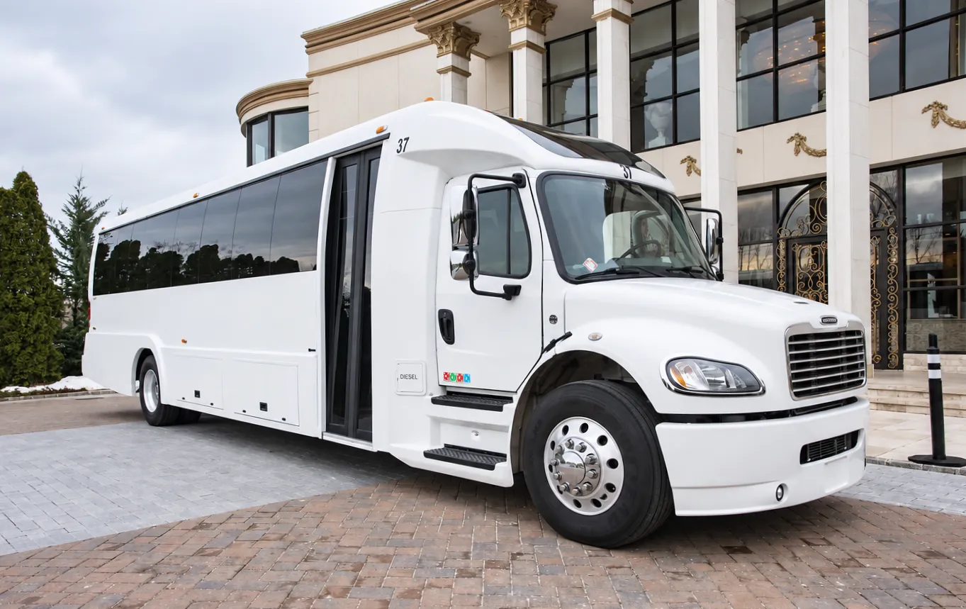 White party bus parked outside an event venue.