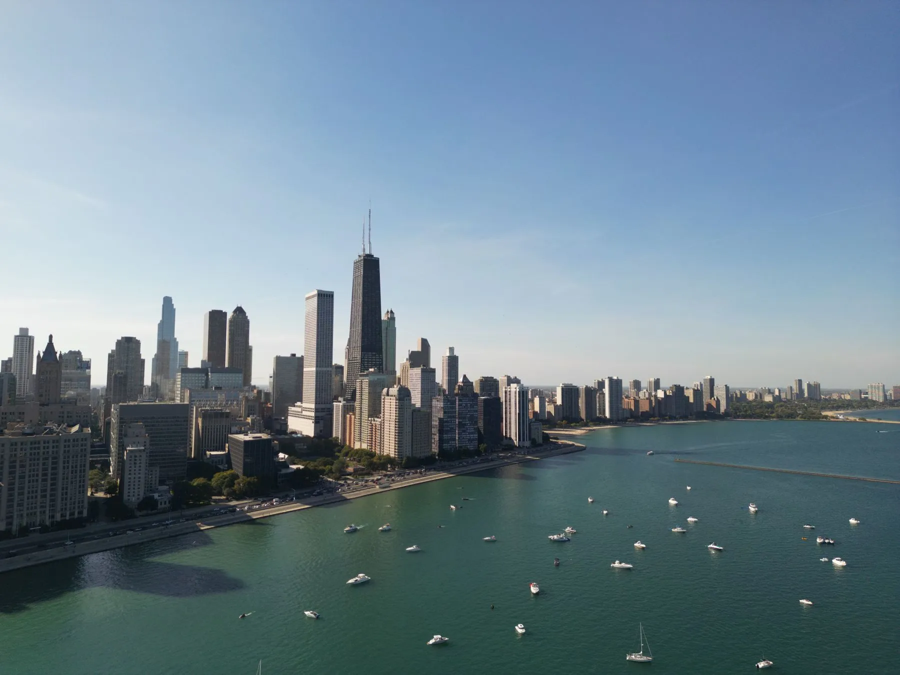 Chicago’s skyline rising above Lake Michigan, with sailboats moored along the shore.